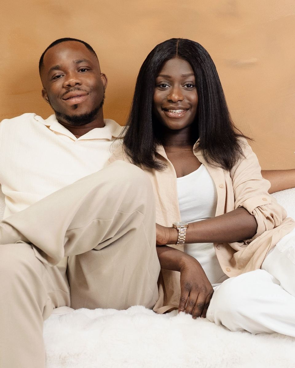 Portrait of Pastor Randolph and Mrs. Patience Adjei smiling, dressed in cream and white